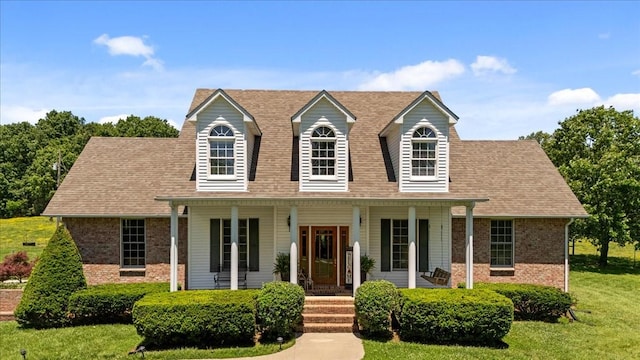 495 Baker Rd, Dickson, TN 37055 - cape cod home with brick siding, covered porch, a front lawn, and roof with shingles