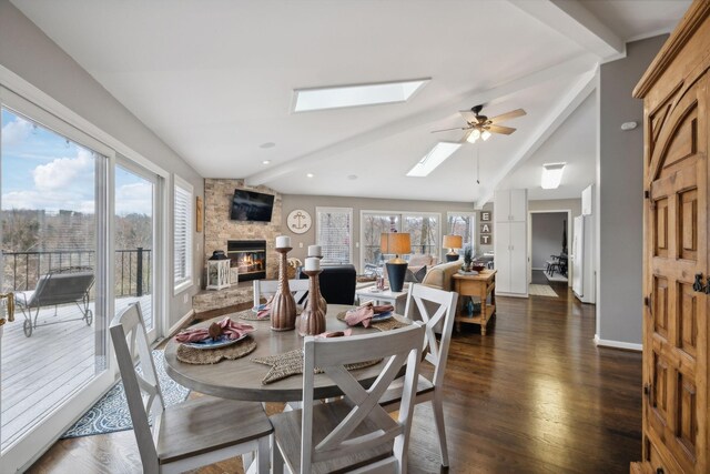 290 Spring Cir, Smithville, TN 37166 - dining room with a skylight, a ceiling fan, a stone fireplace, and dark wood-style flooring