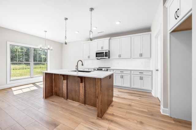 1456 Sango Commons Way, Clarksville, TN 37043 - kitchen featuring appliances with stainless steel finishes, a sink, light wood finished floors, tasteful backsplash, and a chandelier
