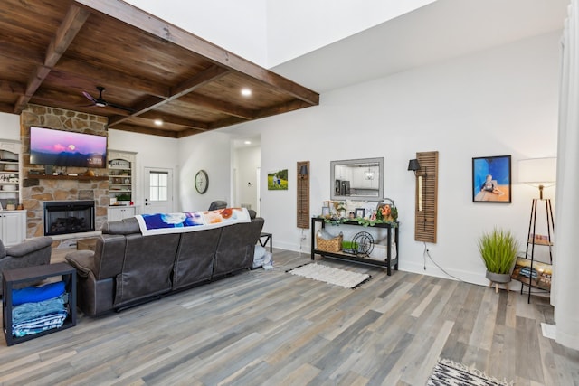 1930 Williams Rd, Lafayette, TN 37083 - living area featuring wooden ceiling with exposed beams, a ceiling fan, wood finished floors, baseboards, and a stone fireplace
