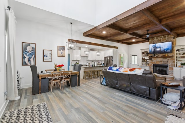 1930 Williams Rd, Lafayette, TN 37083 - living area featuring light wood-style flooring, wooden ceiling with exposed beams, a fireplace, ceiling fan, and baseboards