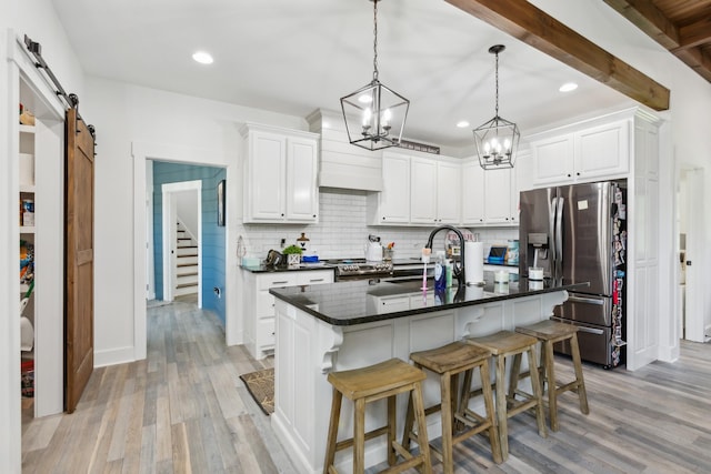 1930 Williams Rd, Lafayette, TN 37083 - kitchen featuring stainless steel appliances, a sink, a barn door, tasteful backsplash, and light wood finished floors