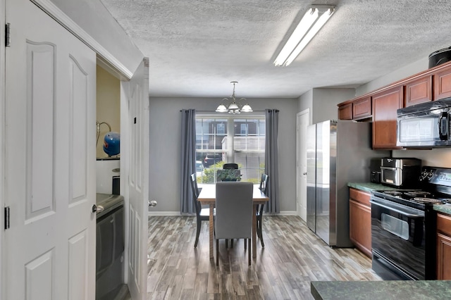 362 Shoshone Pl, Murfreesboro, TN 37128 - kitchen with black appliances, a chandelier, washer / clothes dryer, a textured ceiling, and light wood-style floors