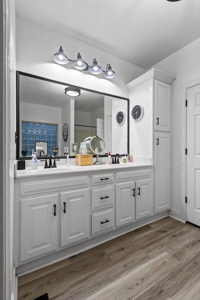 full bath featuring double vanity and wood finished floors
