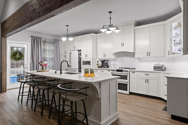 kitchen featuring premium appliances, a chandelier, decorative backsplash, and light countertops