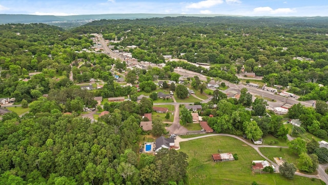 aerial view of property and surrounding area with a heavily wooded area