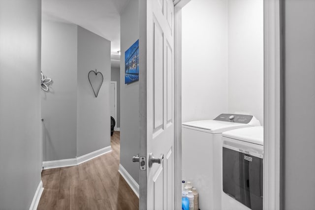laundry room featuring independent washer and dryer, wood finished floors, and baseboards