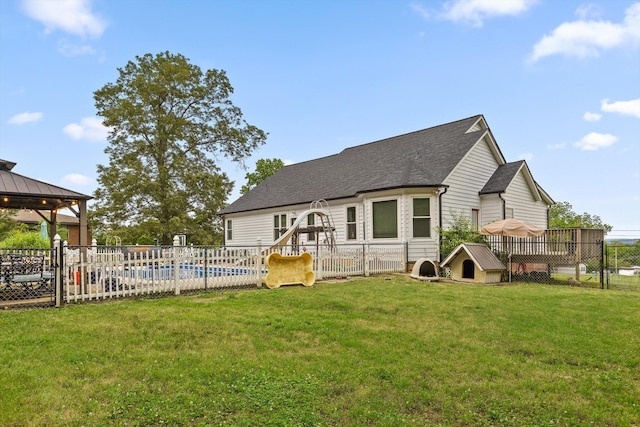 rear view of property featuring a gazebo and a shingled roof