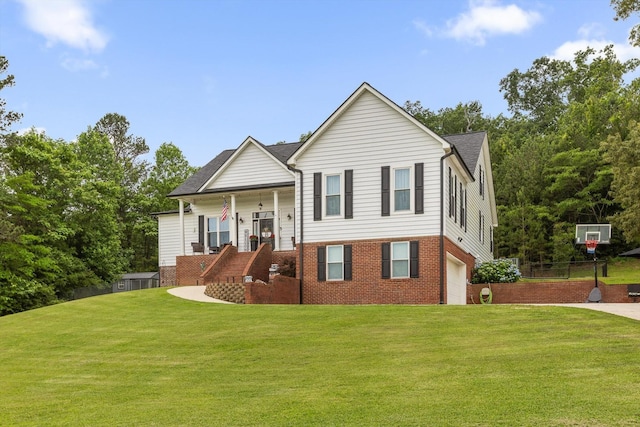 view of front facade with a front yard, an attached garage, covered porch, brick siding, and stairway