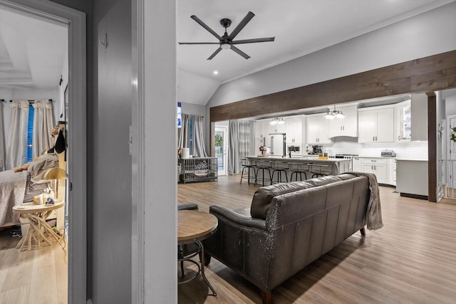 living area with ceiling fan, light wood finished floors, vaulted ceiling, and recessed lighting