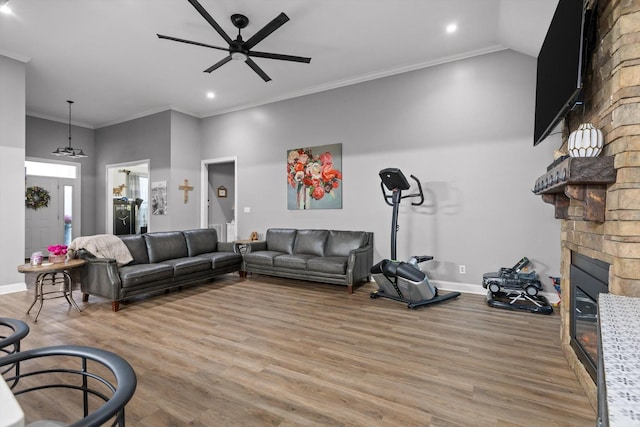 living area featuring ceiling fan, a fireplace, recessed lighting, light wood-style floors, and baseboards