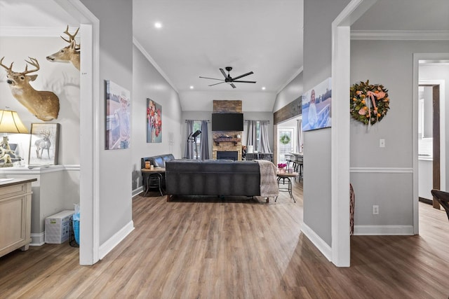 living room with crown molding, light wood finished floors, baseboards, a ceiling fan, and recessed lighting