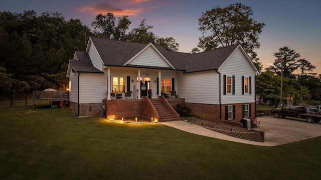 single story home featuring stairway, a front lawn, covered porch, and a shingled roof