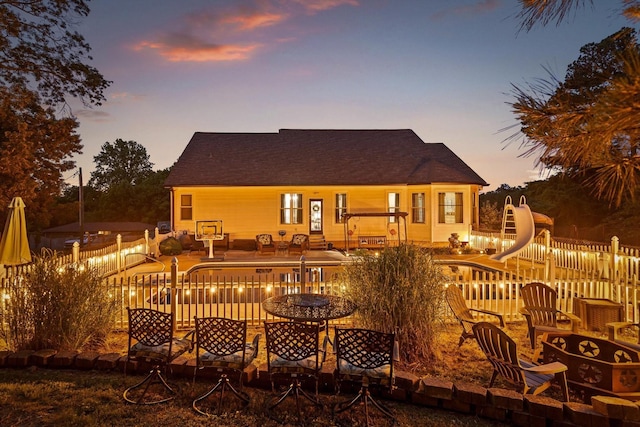 back of property at dusk featuring a patio area and a fire pit