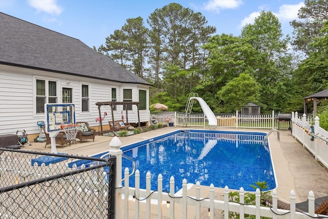view of pool featuring a water slide, a fenced backyard, and a patio