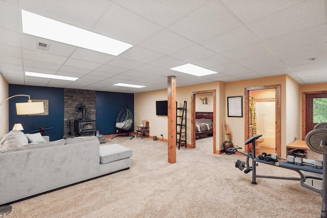 4455 Tarsus Rd, Palmyra, TN 37142 - carpeted living room with a wood stove, a paneled ceiling, and baseboards