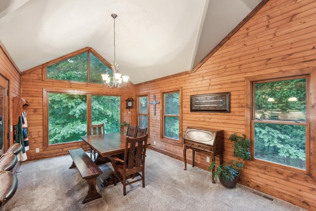4455 Tarsus Rd, Palmyra, TN 37142 - carpeted dining area with vaulted ceiling, a chandelier, and wood walls
