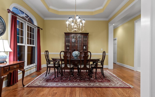 2385 Clear Brooks Dr, Signal Mountain, TN 37377 - dining room with a raised ceiling, wood finished floors, a chandelier, ornamental molding, and baseboards