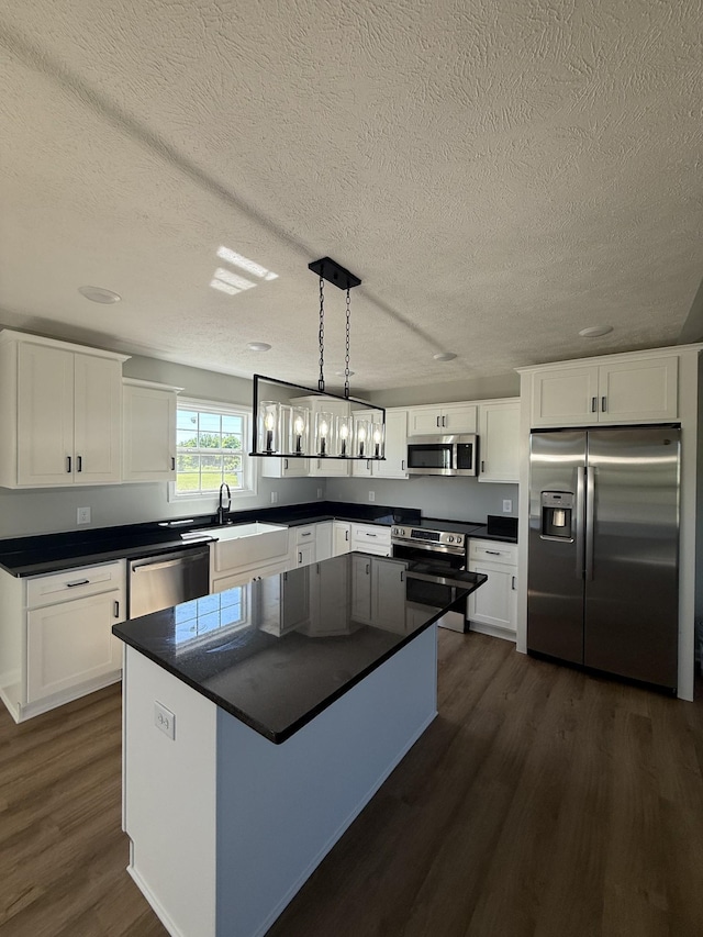1331 Springplace Rd, Lewisburg, TN 37091 - kitchen with stainless steel appliances, dark wood-style floors, dark countertops, a textured ceiling, and white cabinetry