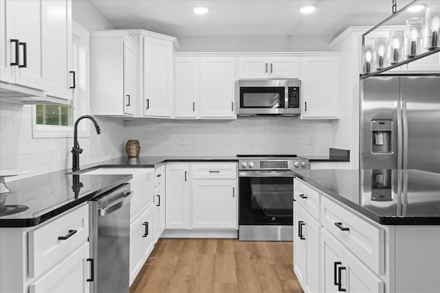 1331 Springplace Rd, Lewisburg, TN 37091 - kitchen with stainless steel appliances, white cabinetry, backsplash, light wood-type flooring, and recessed lighting