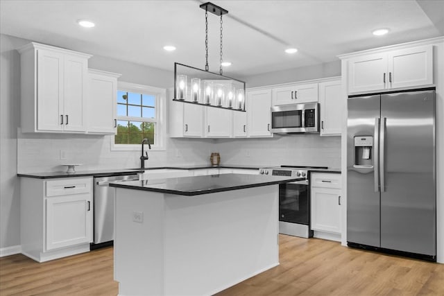 1331 Springplace Rd, Lewisburg, TN 37091 - kitchen featuring stainless steel appliances, dark countertops, white cabinetry, a center island, and light wood-style flooring