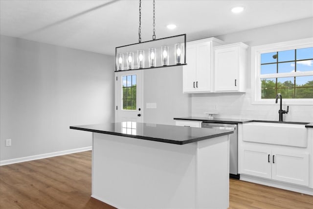 1331 Springplace Rd, Lewisburg, TN 37091 - kitchen with dishwasher, dark countertops, a kitchen island, light wood-style floors, and plenty of natural light