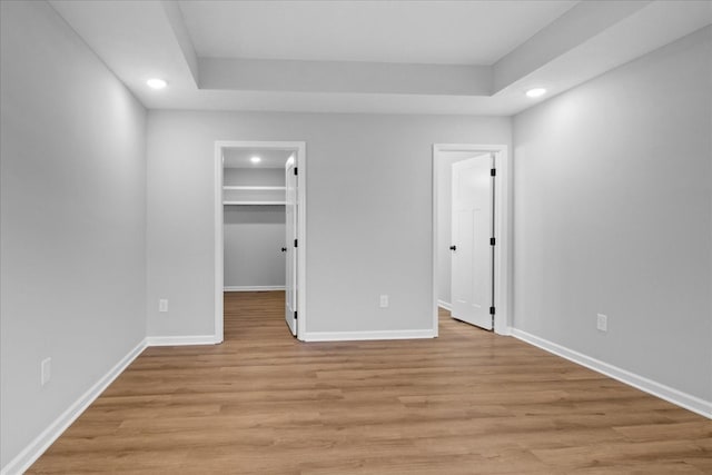 1331 Springplace Rd, Lewisburg, TN 37091 - unfurnished bedroom featuring recessed lighting, light wood-type flooring, a walk in closet, and a tray ceiling