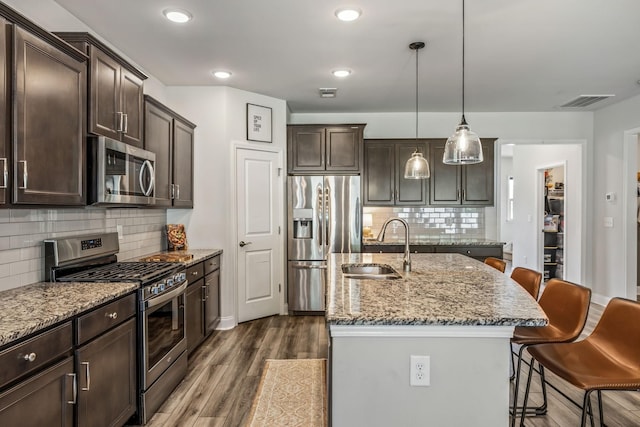321 Union Pier Dr, Mount Juliet, TN 37122 - kitchen featuring appliances with stainless steel finishes, a sink, a kitchen bar, dark wood-type flooring, and dark brown cabinetry
