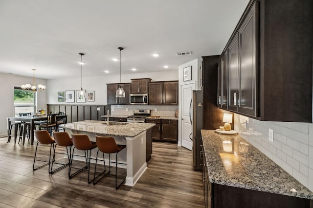 321 Union Pier Dr, Mount Juliet, TN 37122 - kitchen featuring appliances with stainless steel finishes, a sink, dark brown cabinetry, a kitchen breakfast bar, and dark wood-style flooring
