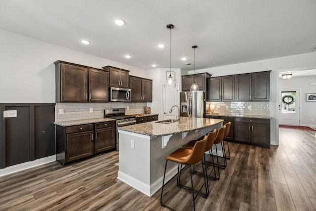 321 Union Pier Dr, Mount Juliet, TN 37122 - kitchen featuring stainless steel appliances, a sink, dark wood-type flooring, dark brown cabinets, and a breakfast bar area