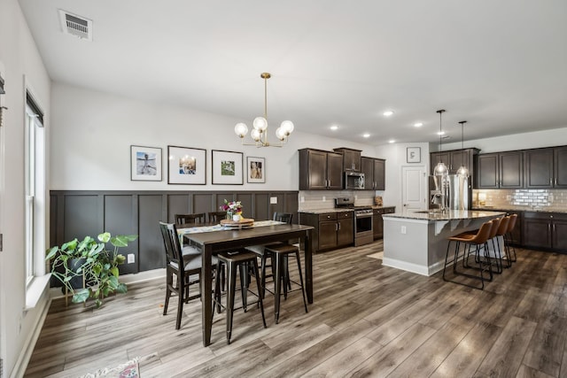 321 Union Pier Dr, Mount Juliet, TN 37122 - dining area featuring a chandelier, wood finished floors, recessed lighting, wainscoting, and a decorative wall