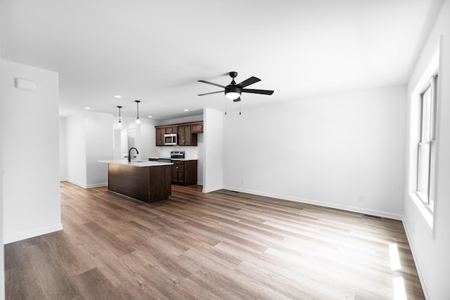 27 Sevier St, Clarksville, TN 37042 - unfurnished living room featuring a sink, recessed lighting, a ceiling fan, wood finished floors, and baseboards