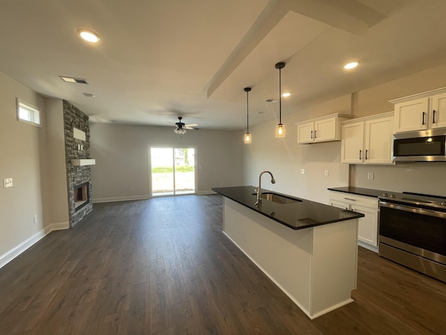 53 Charleston Cv, Clarksville, TN 37043 - kitchen with appliances with stainless steel finishes, dark countertops, ceiling fan, open floor plan, and white cabinetry