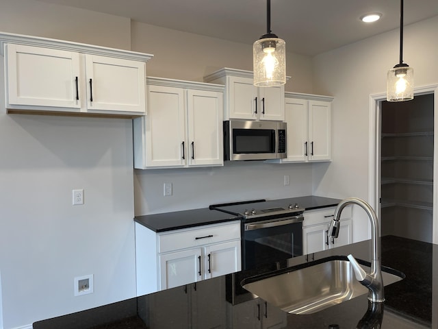 53 Charleston Cv, Clarksville, TN 37043 - kitchen with appliances with stainless steel finishes, dark countertops, white cabinetry, decorative light fixtures, and recessed lighting