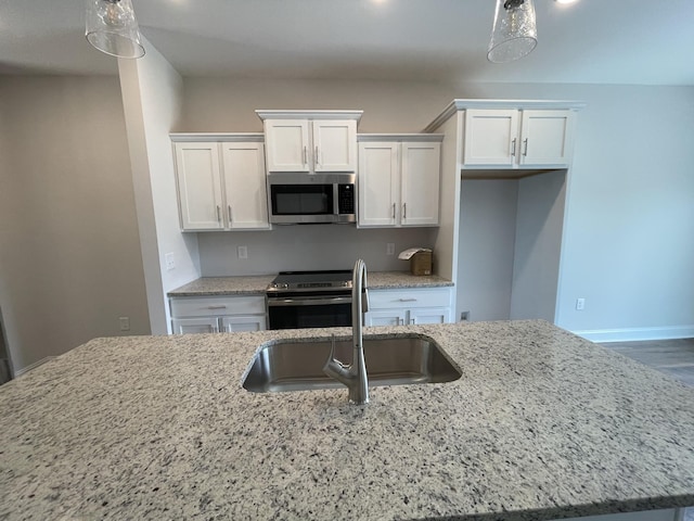 57 Charleston Cv, Clarksville, TN 37043 - kitchen with appliances with stainless steel finishes, white cabinetry, light stone counters, and pendant lighting