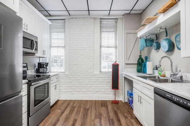 105 W Walnut St, Smithville, TN 37166 - kitchen featuring appliances with stainless steel finishes, a sink, brick wall, light countertops, and dark wood-style flooring