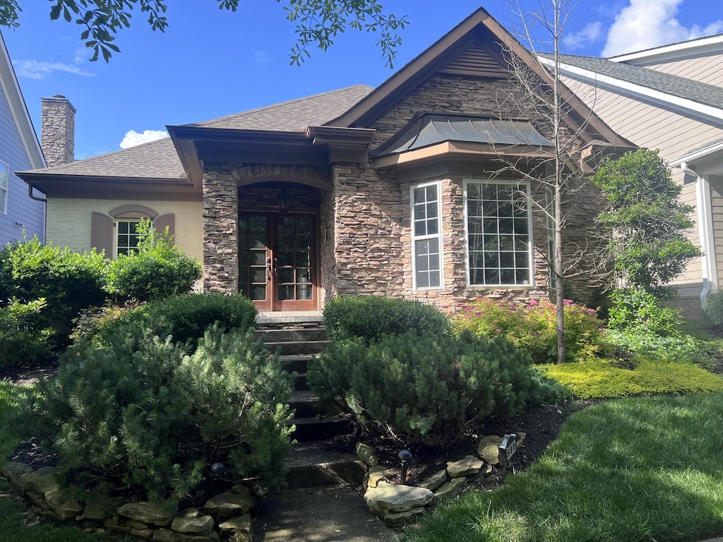 680 Pebble Springs Dr, Franklin, TN 37067 - view of front of house featuring stone siding, a chimney, roof with shingles, and french doors