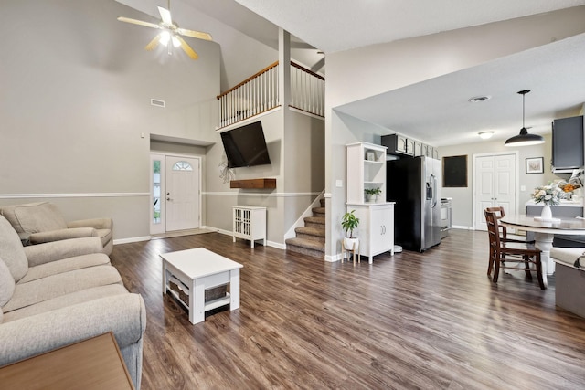2236 Kim Dr, Clarksville, TN 37043 - living area featuring dark wood-type flooring, stairs, ceiling fan, baseboards, and a high ceiling
