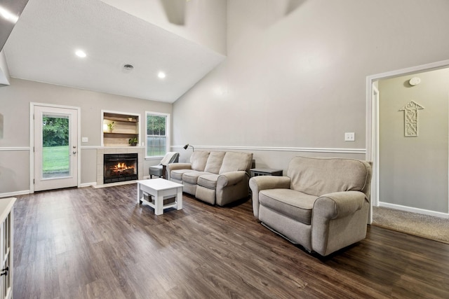 2236 Kim Dr, Clarksville, TN 37043 - living room featuring a tiled fireplace, dark wood-style floors, a towering ceiling, and recessed lighting