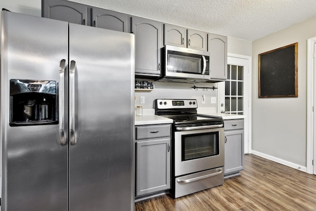 2236 Kim Dr, Clarksville, TN 37043 - kitchen with appliances with stainless steel finishes, gray cabinets, dark wood-style flooring, light countertops, and a textured ceiling