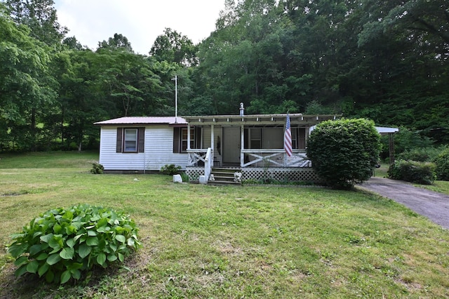 9097 Denton Rd, Linden, TN 37096 - manufactured / mobile home featuring covered porch, a front lawn, metal roof, and a wooded view