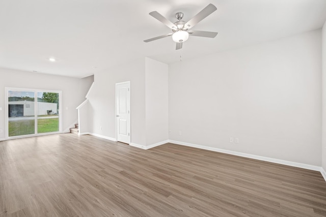 2028 Lala Loop, White Bluff, TN 37187 - unfurnished living room with stairs, wood finished floors, baseboards, ceiling fan, and recessed lighting