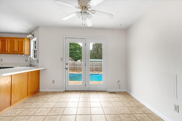 1910 Burlington Cir, Columbia, TN 38401 - kitchen featuring a sink, brown cabinetry, a ceiling fan, light countertops, and baseboards