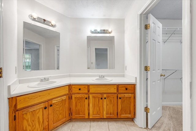 1910 Burlington Cir, Columbia, TN 38401 - bathroom featuring double vanity, a spacious closet, a textured ceiling, and tile patterned flooring
