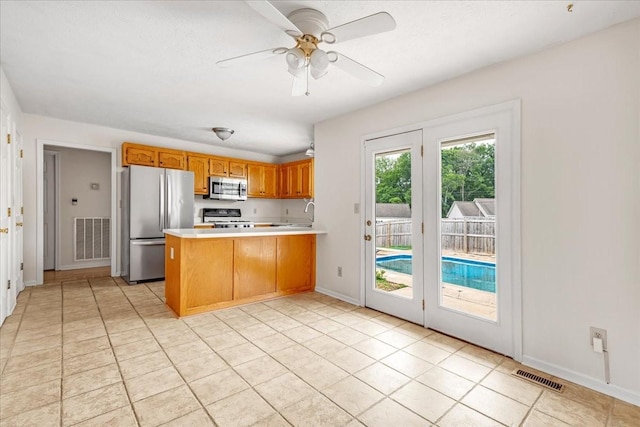 1910 Burlington Cir, Columbia, TN 38401 - kitchen with stainless steel appliances, a peninsula, light countertops, brown cabinetry, and baseboards