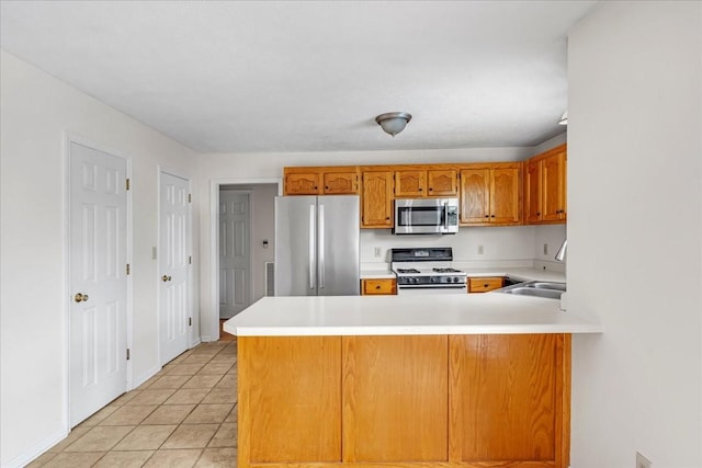 1910 Burlington Cir, Columbia, TN 38401 - kitchen with stainless steel appliances, a sink, a peninsula, light countertops, and brown cabinets