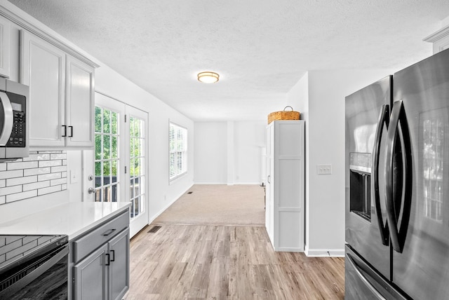 2829 Sharpie Dr, Clarksville, TN 37040 - kitchen with appliances with stainless steel finishes, gray cabinets, light countertops, light wood-type flooring, and backsplash