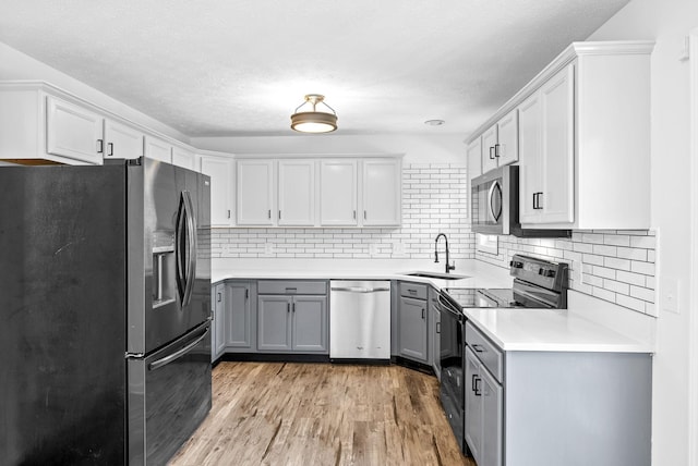 2829 Sharpie Dr, Clarksville, TN 37040 - kitchen with stainless steel appliances, a sink, gray cabinets, tasteful backsplash, and light wood-style floors