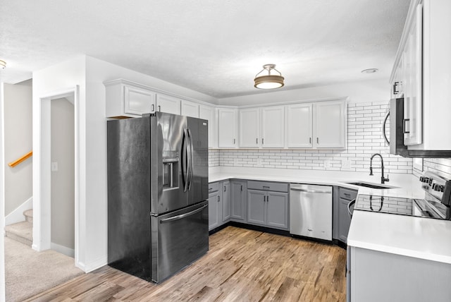 2829 Sharpie Dr, Clarksville, TN 37040 - kitchen with stainless steel appliances, a sink, gray cabinetry, tasteful backsplash, and a textured ceiling