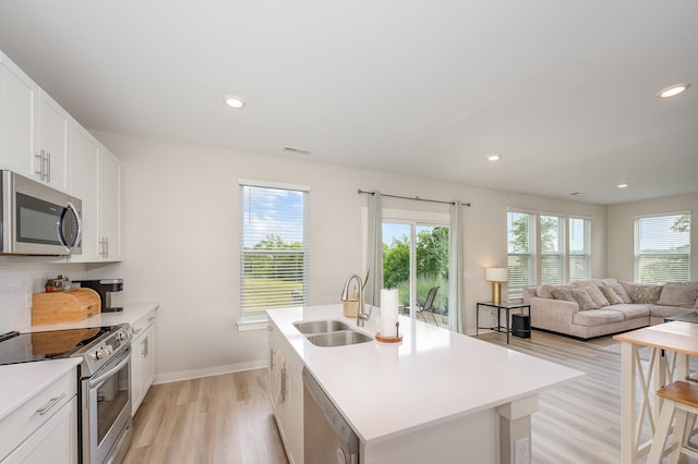 705 Watson Ct, Spring Hill, TN 37174 - kitchen with stainless steel appliances, a sink, light wood-style flooring, an island with sink, and light countertops